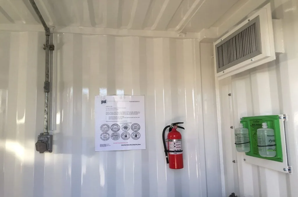 Safety signage, fire extinguisher and eye-wash station in a C1D1 extraction lab